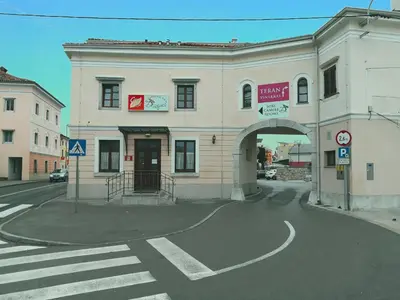 a large white building with an arch on a street at Gostilna pri Dragici, gostilna s prenočišči, d.o.o. in Sežana