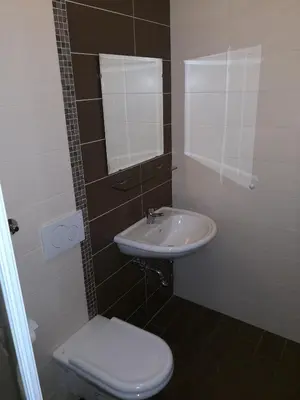 a bathroom with a sink and a toilet and a mirror at Gostilna pri Dragici, gostilna s prenočišči, d.o.o. in Sežana
