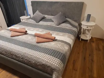 a large bed with two pillows on top of it at Honey Apartment Lendava in Lendava