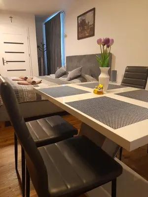 a dining room table with a vase of flowers on it at Honey Apartment Lendava in Lendava