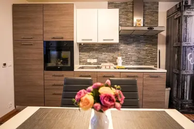 a kitchen with a table and a vase of flowers at Honey Apartment Lendava in Lendava