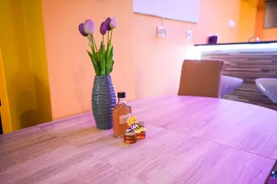 a table with a vase with purple tulips in it at Honey Apartment Lendava in Lendava