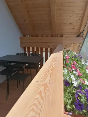 a table and chairs and flowers on a balcony at Apartments Gorski raj in Kranjska Gora