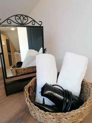 a basket with towels and a blow dryer in front of a mirror at Apartments Gorski raj in Kranjska Gora