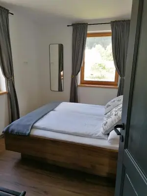 a bedroom with a large bed with a window at Apartments Gorski raj in Kranjska Gora