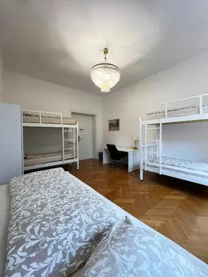 a bedroom with four bunk beds and a chandelier at Rooms Miklošičeva in Ljubljana