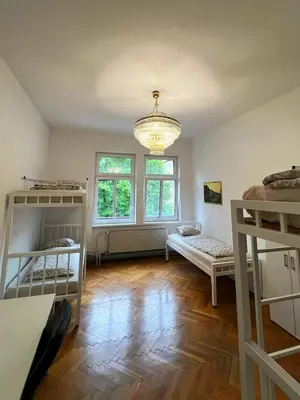 a room with two bunk beds and a chandelier at Rooms Miklošičeva in Ljubljana