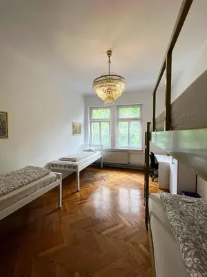 a room with two beds and a chandelier at Rooms Miklošičeva in Ljubljana