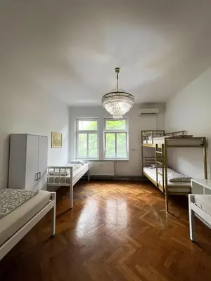 a room with three bunk beds and a chandelier at Rooms Miklošičeva in Ljubljana