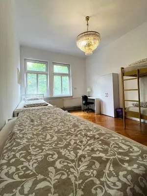 a large bedroom with two beds and a chandelier at Rooms Miklošičeva in Ljubljana