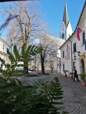 a person walking down a street in front of a church at Vila Radolca apartments & rooms in Radovljica