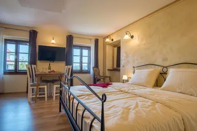 a bedroom with a bed and a table with chairs at Vila Radolca apartments & rooms in Radovljica