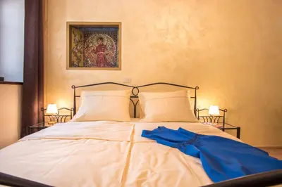 a white bed with a blue dress on it at Vila Radolca apartments & rooms in Radovljica