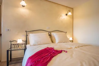 a bedroom with a bed with a red dress on it at Vila Radolca apartments & rooms in Radovljica
