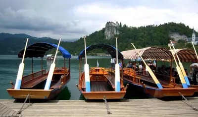 three boats are docked at a dock on the water at Marvellous Face in Bled