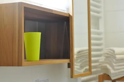 a green cup in a wooden cabinet with towels at Marvellous Face in Bled