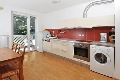 a kitchen with a washer and dryer and a table at Marvellous Face in Bled