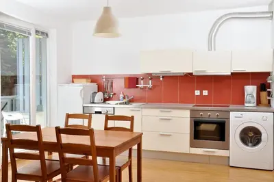 a kitchen with a table and chairs and a kitchen with red at Marvellous Face in Bled