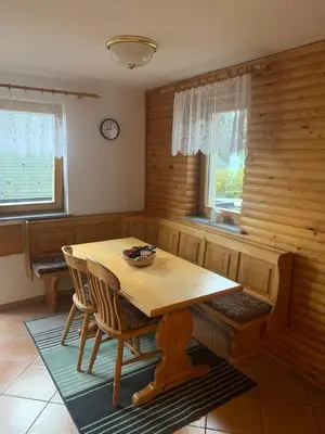 a dining room with a wooden table and chairs at Apartments Nune in Zreče