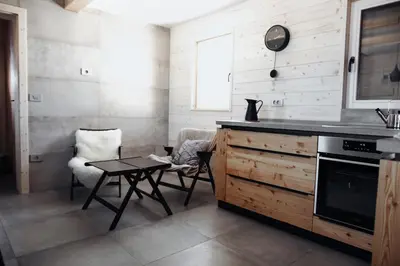a kitchen with a counter and a table and a chair at Chalet Velika Planina with Sauna - I FEEL ALPS in Stahovica