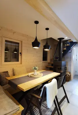 a dining room with a wooden table and a stove at Chalet Velika Planina with Sauna - I FEEL ALPS in Stahovica