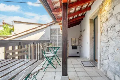a patio with two chairs and a table on a building at Apartma Hiša Pliska in Pliskovica