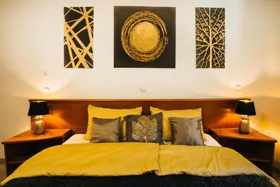 a bedroom with a bed and some pictures on the wall at Aparthotel Rosa 404 in Podčetrtek