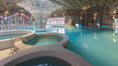 a large swimming pool with a hot tub in a building at Aparthotel Rosa 404 in Podčetrtek