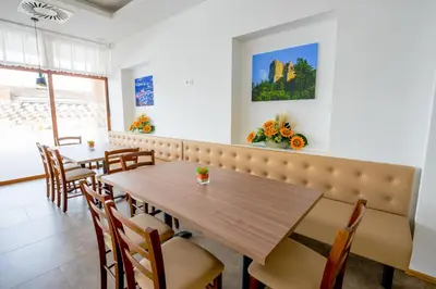 a dining room with a wooden table and chairs at HOTEL BARON in Smlednik