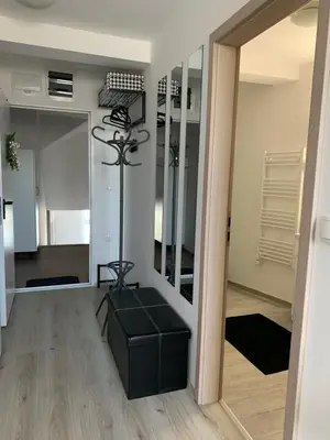 a living room with a mirror and a black ottoman at Apartment Luna in Maribor