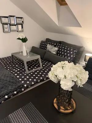 a living room with a couch and a table with flowers at Apartment Luna in Maribor