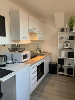 a kitchen with white cabinets and a white microwave at Apartment Luna in Maribor