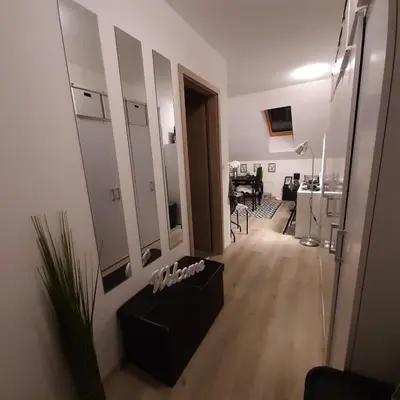 a living room with a black couch and a mirror at Apartment Luna in Maribor