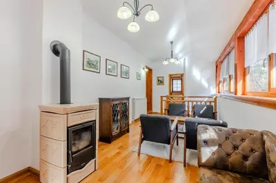 a living room with a fireplace and a table and chairs at Počitniško stanovanje Pri cerkvi in Trenta
