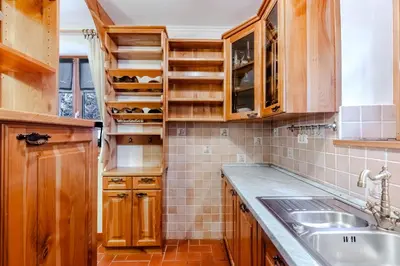 a kitchen with wooden cabinets and a sink at Počitniško stanovanje Pri cerkvi in Trenta