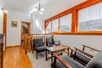 a living room with chairs and a table and windows at Počitniško stanovanje Pri cerkvi in Trenta