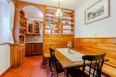 a dining room with a wooden table and chairs at Počitniško stanovanje Pri cerkvi in Trenta