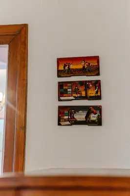 three pictures hanging on a wall next to a mirror at Počitniško stanovanje Pri cerkvi in Trenta