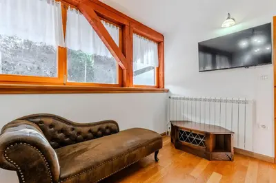 a living room with a leather couch and a table at Počitniško stanovanje Pri cerkvi in Trenta