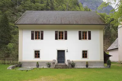 a white house with a black roof at Počitniško stanovanje Pri cerkvi in Trenta