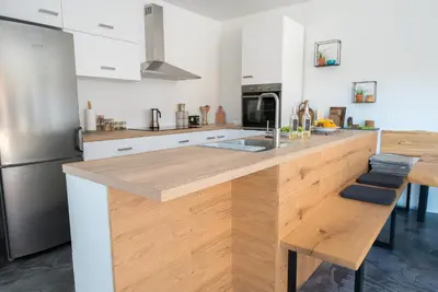 a kitchen with a wooden counter top and a refrigerator at Hiša sonca Toti breg in Svečina