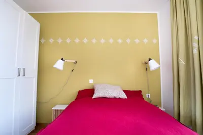 a bedroom with a pink bed with two lamps at Hiša sonca Toti breg in Svečina