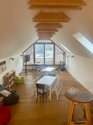 a room with tables and chairs and a large window at Hiša sonca Toti breg in Svečina