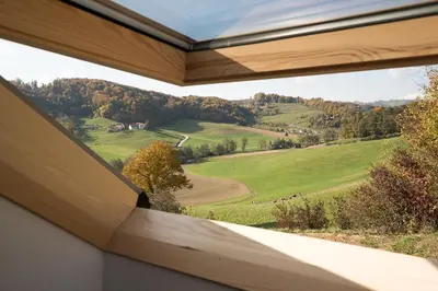 a window in a house with a view of a field at Hiša sonca Toti breg in Svečina