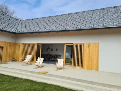 a house with two chairs and a patio at Hiša sonca Toti breg in Svečina