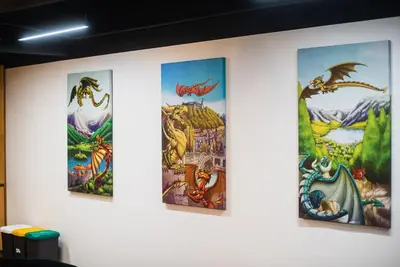 a group of four paintings on a wall at Dragons Dream Hostel in Ljubljana