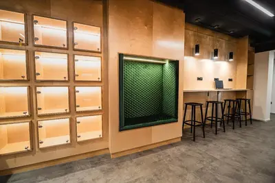 a bar in a room with wooden cabinets and stools at Dragons Dream Hostel in Ljubljana