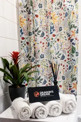 a bathroom with towels and a sign on a counter at Dragons Dream Hostel in Ljubljana