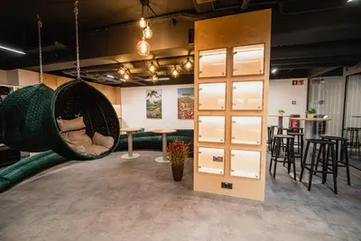 a room with a hanging hammock and a bar at Dragons Dream Hostel in Ljubljana
