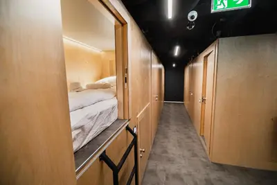 a hallway with a bed in a small room at Dragons Dream Hostel in Ljubljana